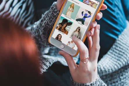 A person scrolling the online shop on their phone