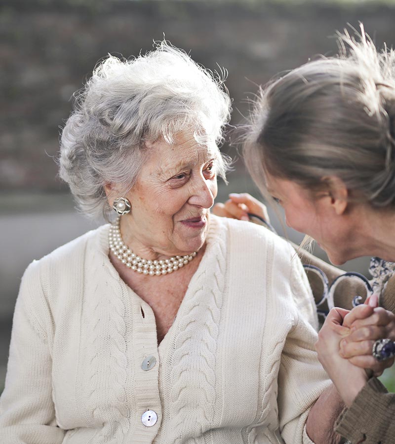 An elderly woman accompanied by another woman