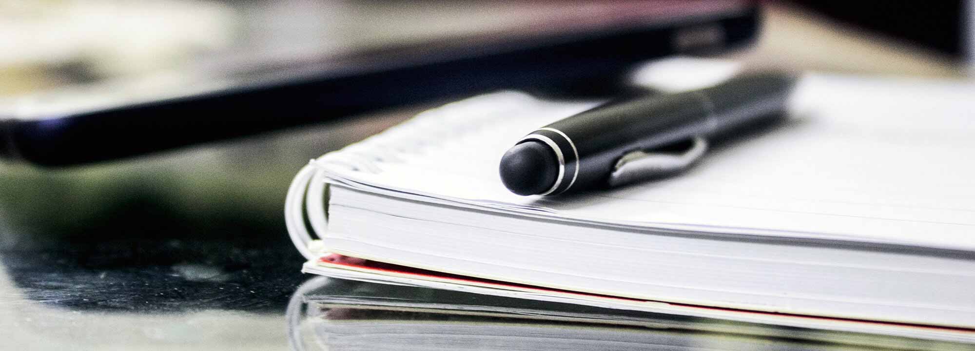 A pen resting on a notepad