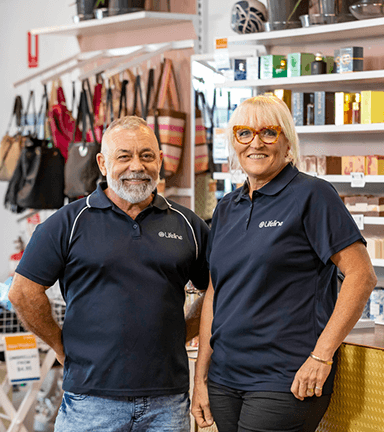 An older man and an older woman stand in vibrant Lifeline shop.